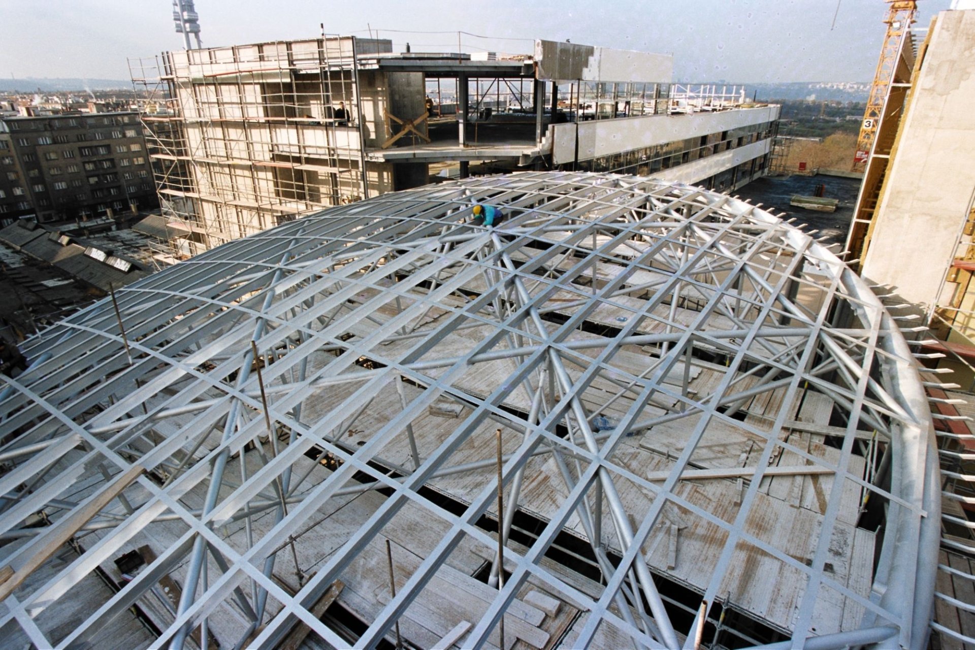 The rotunda taking shape — the steel lattice of the arcade's domed roof under construction, the building rising behind it.